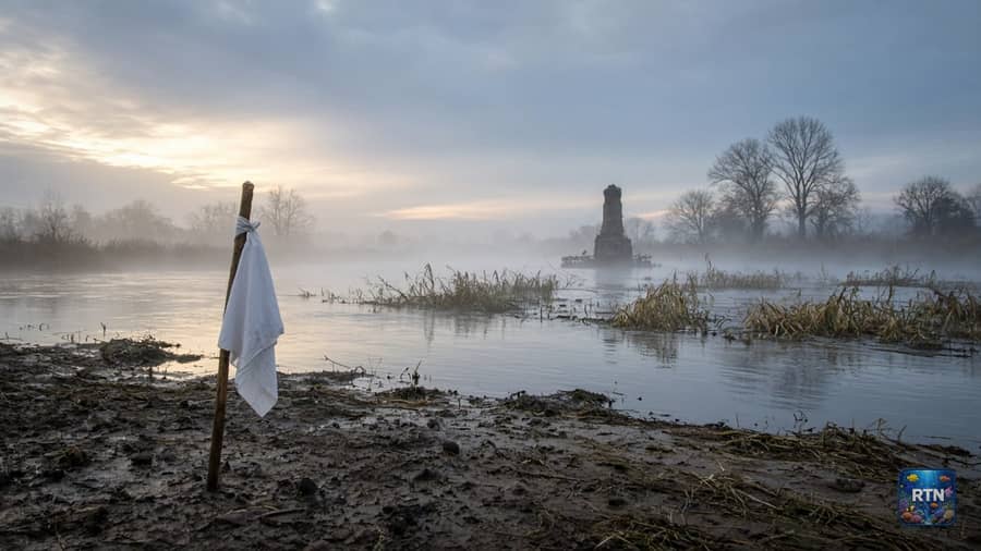 AI-generated illustration: a white cloth tied to a stick on a quiet, misty riverbank